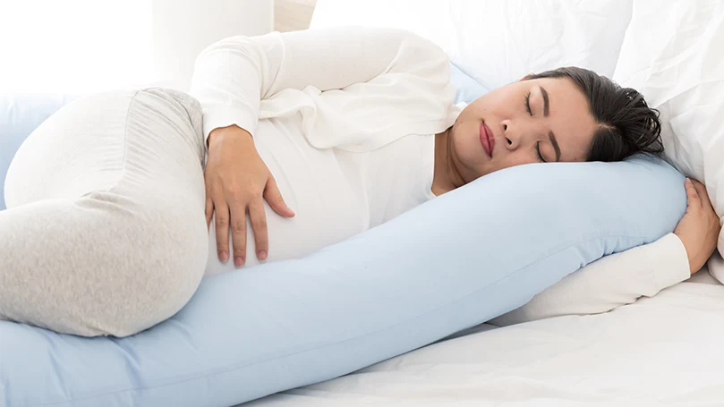 an image of a pregnant woman sleeping on her side