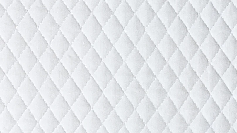 A white mattress with a diamond pattern.