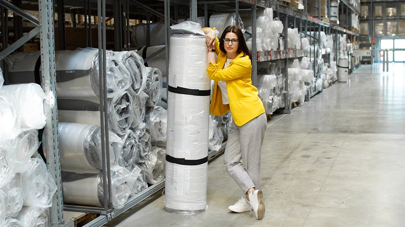 an image of a woman holding a mattress rolled and packed