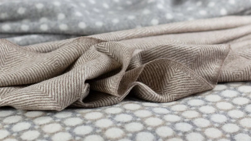 an image of scooms merino wool blanket thrown on a bed