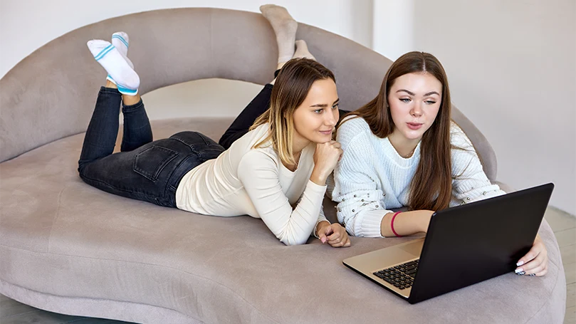 an image of two women laying on a divan bed base