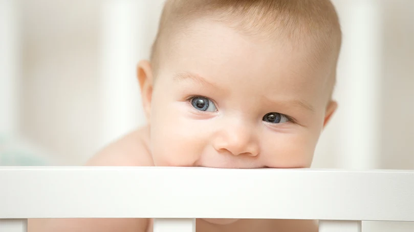 an close up image of a baby in a cot bed