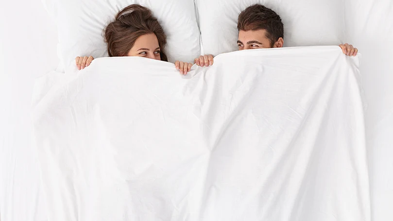 A couple laying on a medium firm mattress