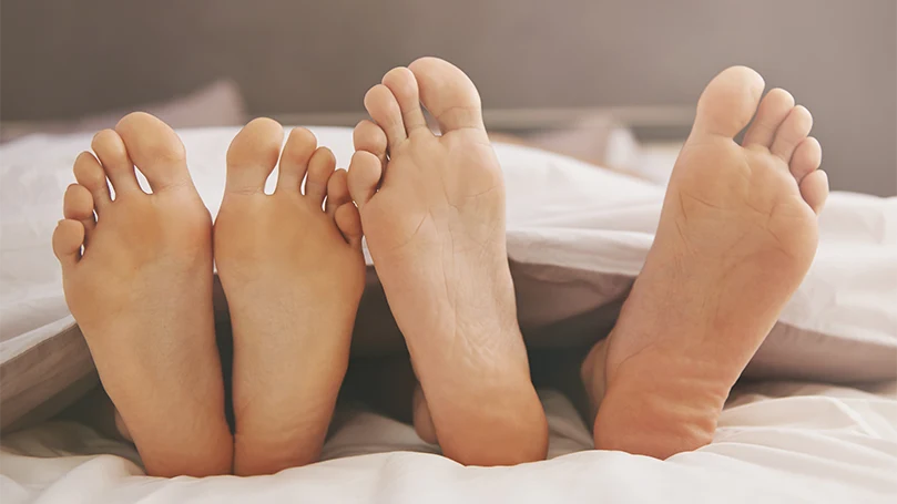 an image of a couple sleeping with legs straight in the bed