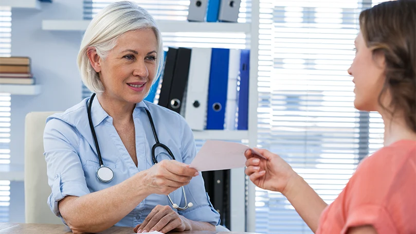 an image of a doctor giving her patient a referral letter