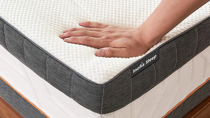 a hand pressing Inofia memory foam mattress topper