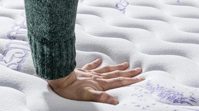 an image of a hand pressing the top layer of Vesgantti Lavender mattress
