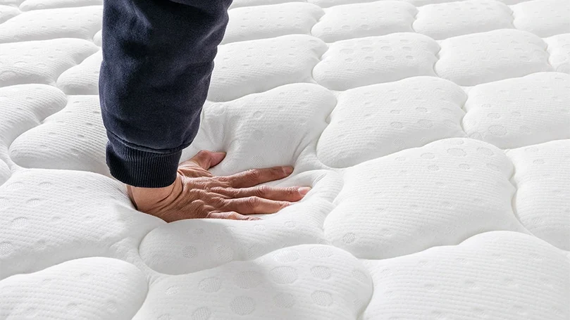 an image of a man pressing Vesgantti Pro Hybrid mattress