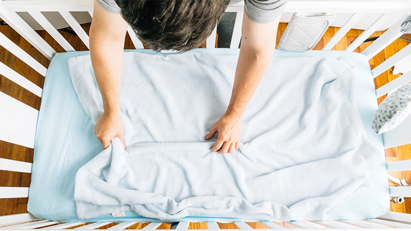 an image of a man setting up a cot mattress