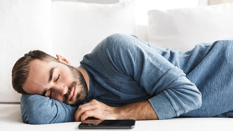 an image of a man sleeping next to his cellphone