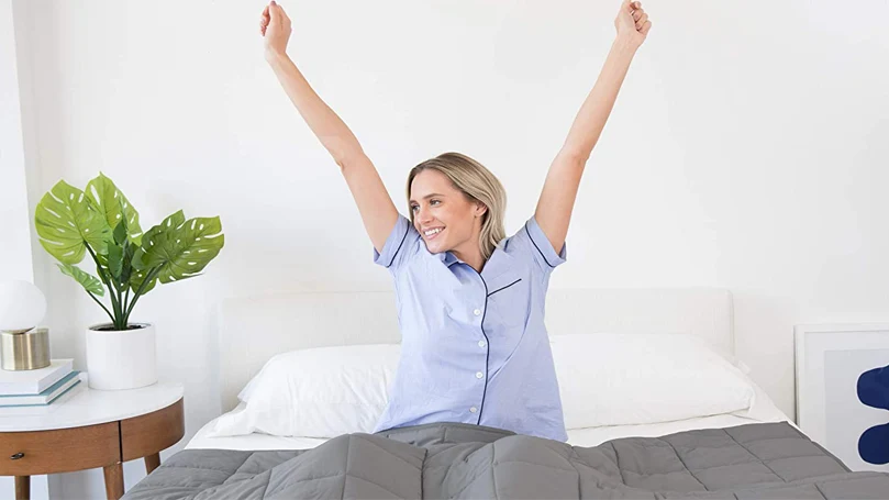an image of a woman waking up in a bed with luna weighted blanket