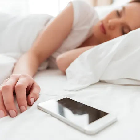 An image of a woman sleeping next to her phone
