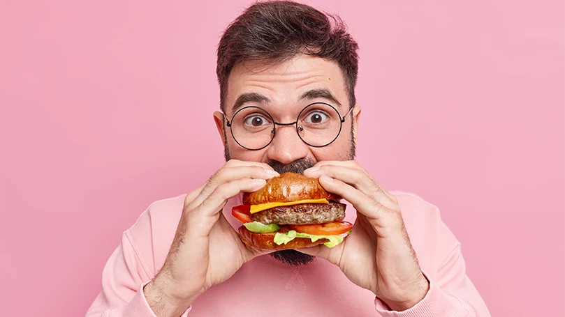 An image of a man eating hamburger.