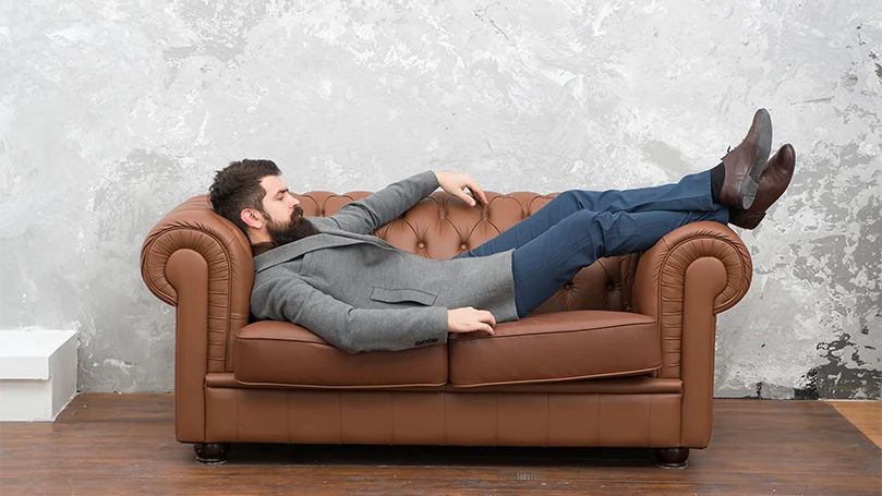 An image of a man napping on a sofa.