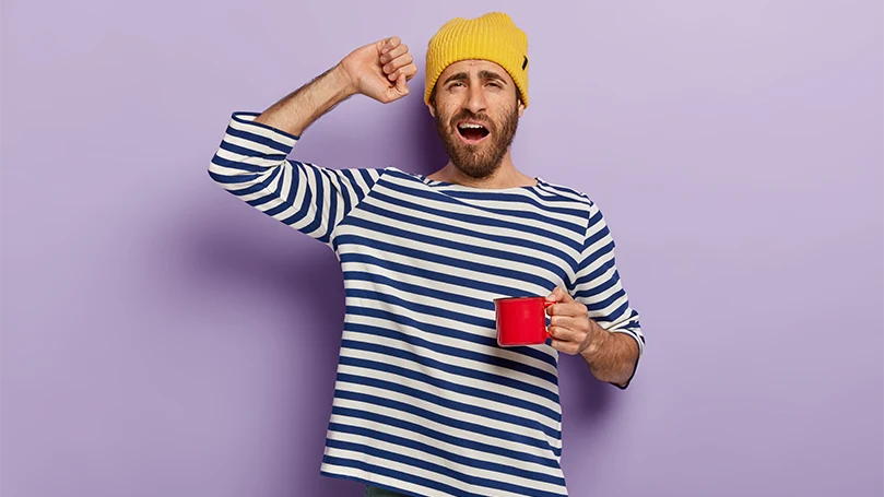 An image of A man starting his morning with a cup of coffee.