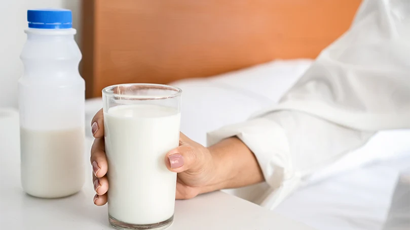 An image of A woman holding a glass of milk.