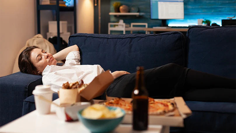 An image of a woman laying on her bed after a meal.