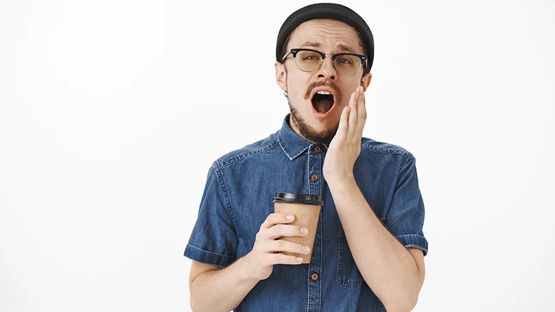 A-young-man-yawning-before-a-coffee-nap