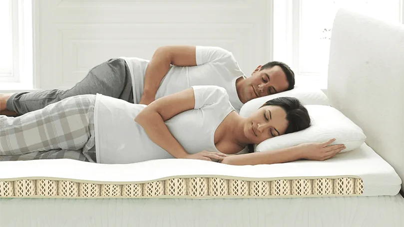 An image of a couple sleeping on Dormeo Octaspring Classic mattress topper.