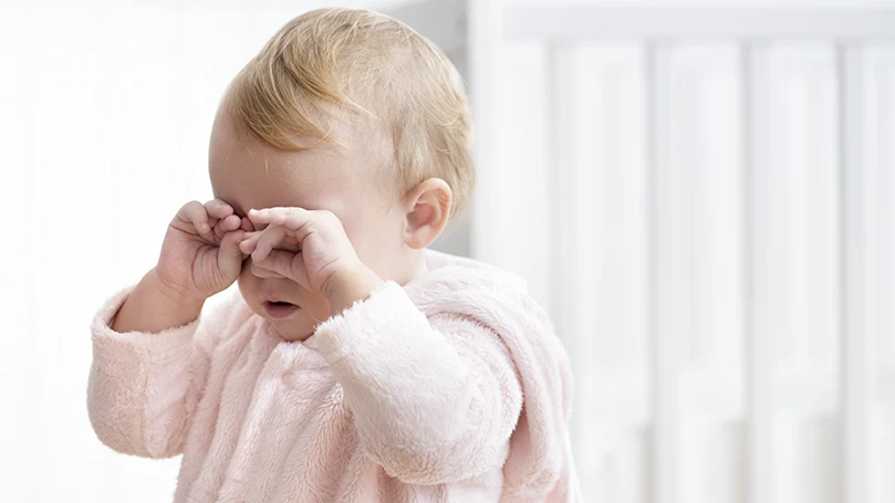An image of a baby rubbing its eyes