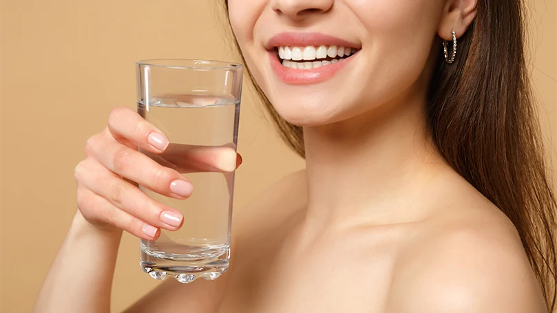 An image of a woman holding a glass of water.