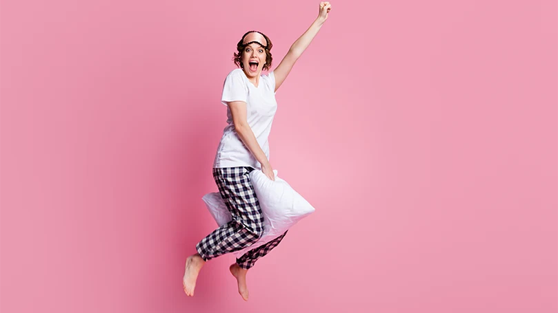 An image of a woman holding a pillow between knees.