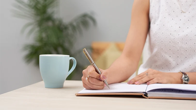 An image of a woman writing down in her dream journal.