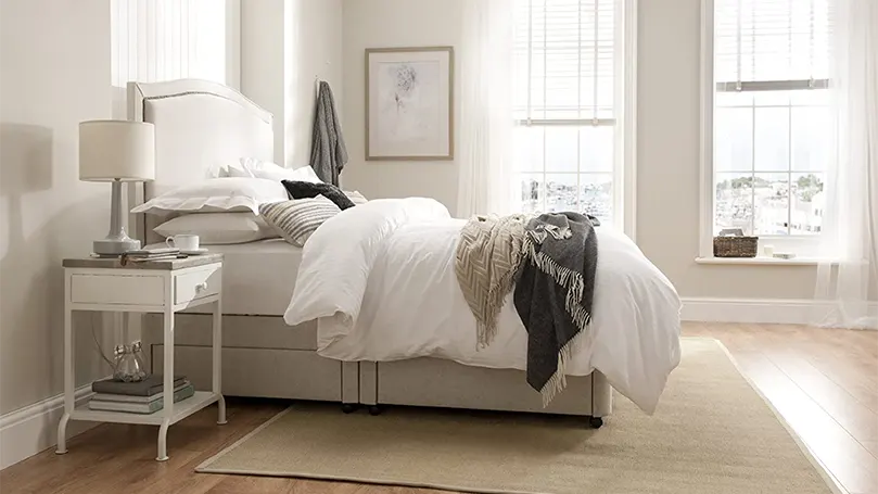 An image of Rest Assured 2000 Pocket Sprung mattress in a bedroom.