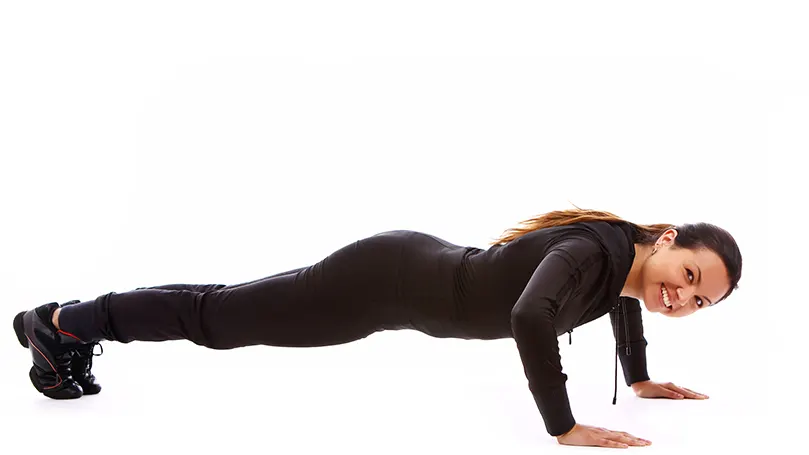 An image of a beautiful young woman exercising and doing pushups before bed.