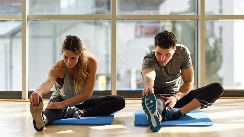 An image of a couple stretching and exercising in the morning.