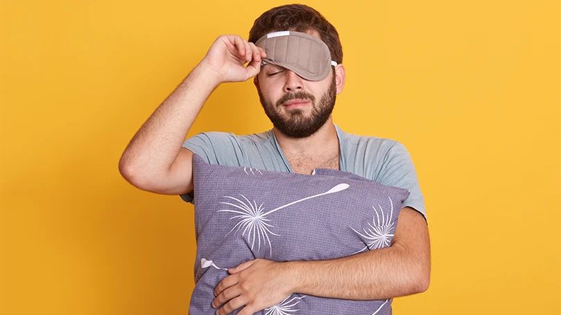 An image of a man having an eye mask on his face.