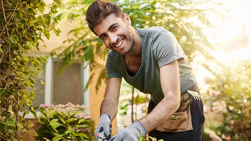 An image of a man working in garden under the daylight.