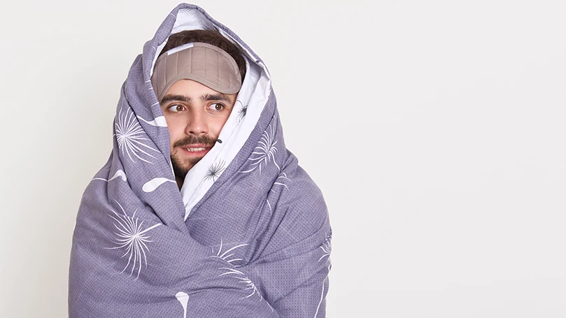 An image of a man wrapped in a purple blanket.