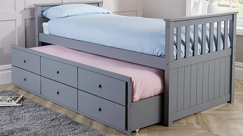 An image of a trundle bed with drawers in a bedroom,