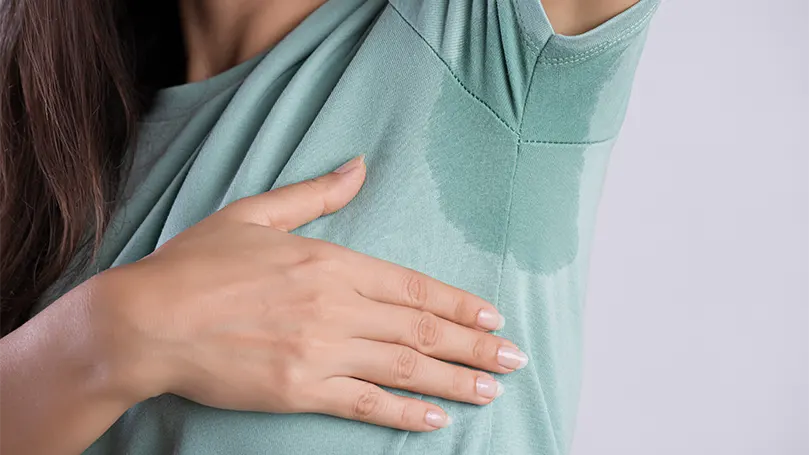 An image of a woman sweating under arm.