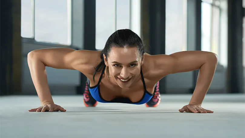 An image of a young woman doing pushup.