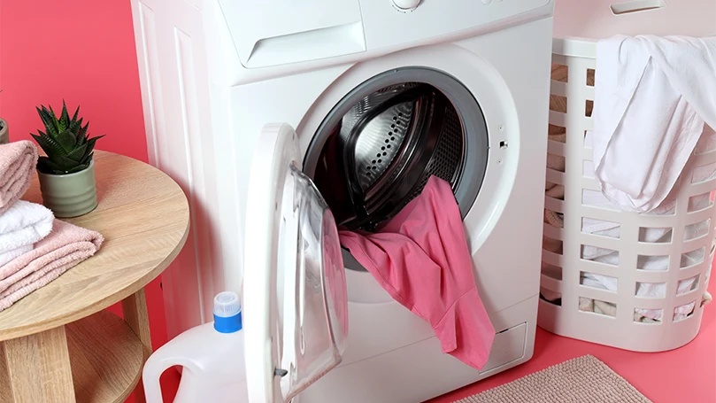 An image of bedding and clothes in a washing machine.