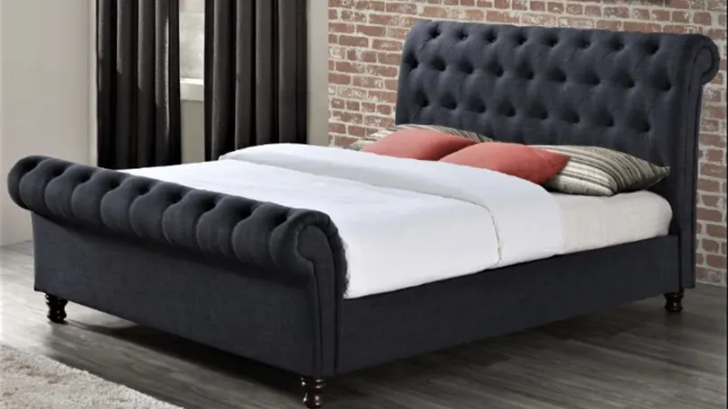 An image of black sleigh bed in a bedroom.