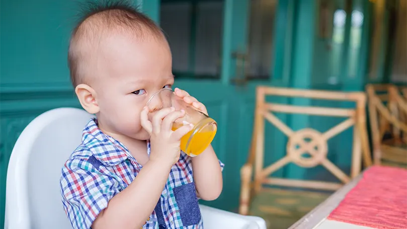 An image of 18 month old baby drinks juice.