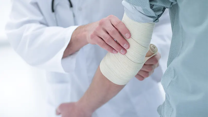 An image of a doctor applying a bandage to stop bleeding.