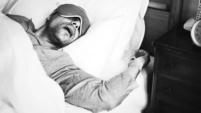 An image of a man sleeping and snoring.