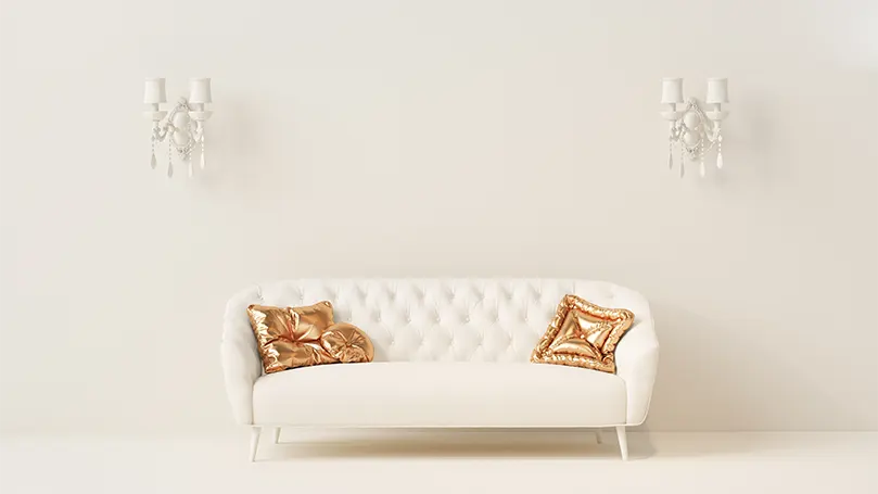 An image of a modern couch with two golden pillows