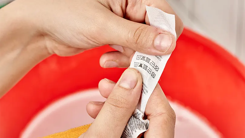 An image of a woman checking the care instructions.