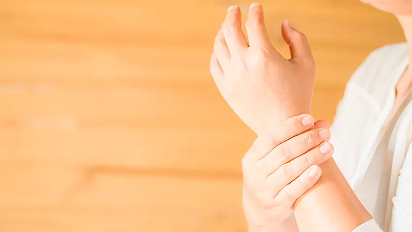 An image of a woman holding a wrist of her hand.