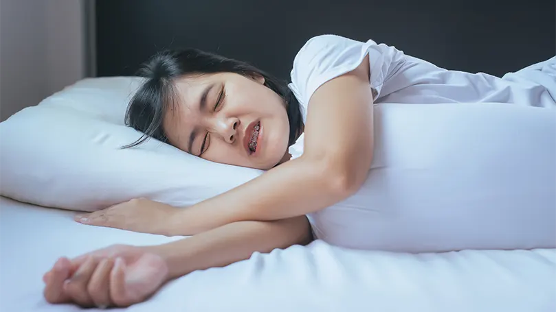 An image of a woman suffering from bruxism in sleep.