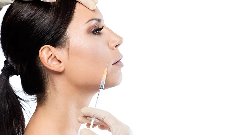 An image of a young woman getting an injection of botox.