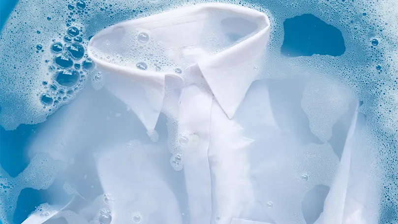 An image of a cotton shirt in warm water with detergent.