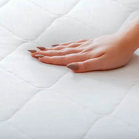 A hand pressing a mattress