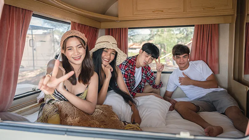 An image of a group of Asian friends in a camping van.