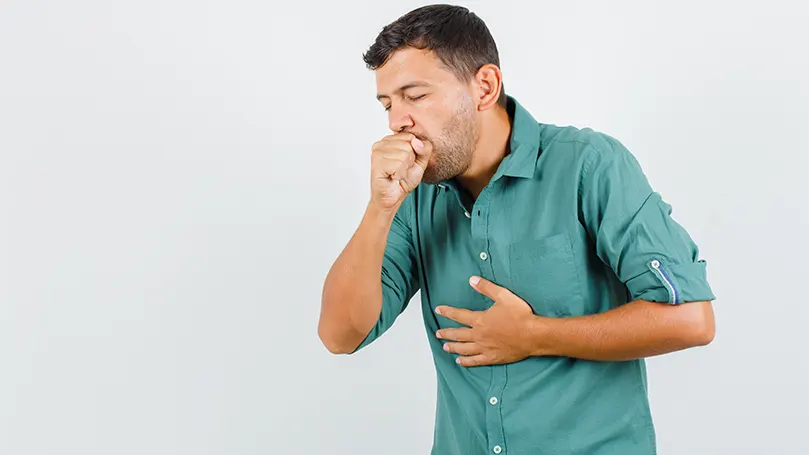 An image of a man coughing.